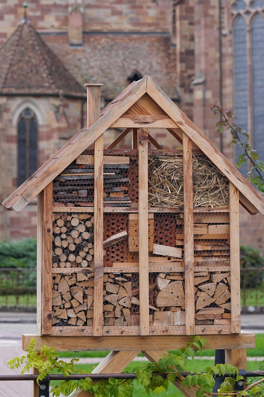 Handcrafted insect hotel made of natural materials like wood, straw, and bark for promoting pollinator health in sustainable gardens.